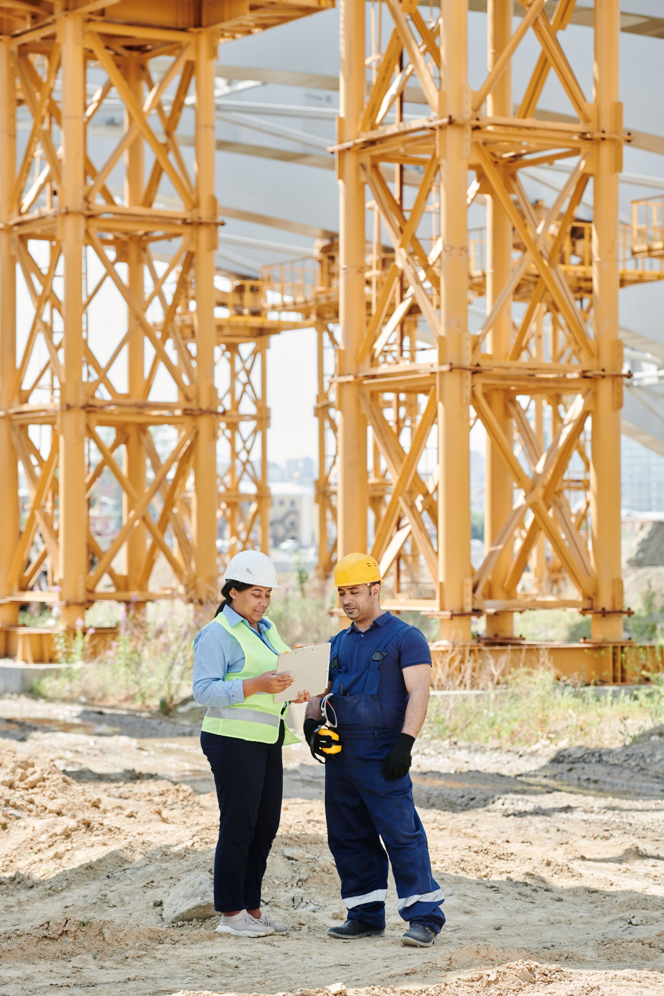 Construction engineer and field specialist reviewing plans